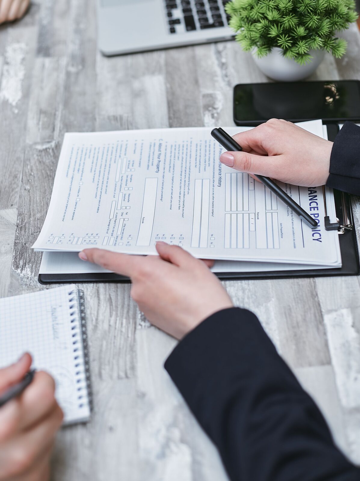 Hænder der gennemgår compliance-dokumenter på et kontor